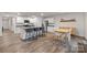 Open-concept kitchen and dining area with stainless appliances, center island with seating, and natural wood dining table at 2766 Sherrills Stream Dr, Sherrills Ford, NC 28673
