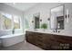 Bright bathroom features dual vanities with modern fixtures, soaking tub, and large windows for natural light at 3020 Georgia Ave, Charlotte, NC 28205