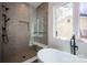 Spa bathroom featuring large tiled shower with bench, a soaking tub and window views at 3020 Georgia Ave, Charlotte, NC 28205