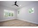 Sun-lit bedroom featuring sleek ceiling fan, three windows, and hardwood floors at 3020 Georgia Ave, Charlotte, NC 28205