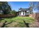 View of the home's exterior and expansive backyard, complemented by lush greenery and a privacy fence at 3020 Georgia Ave, Charlotte, NC 28205