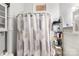 Bathroom features a shower with a stylish curtain, white walls, and useful shelving at 310 N Central Ave, Landis, NC 28088