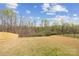 Large, grassy backyard with a wooded treeline, enclosed by fencing on either side at 314 Contentment Dr # 192B, Locust, NC 28097