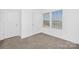 Bright, unfurnished room with carpet and two large windows, offering a clean and versatile space at 314 Contentment Dr # 192B, Locust, NC 28097