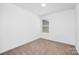 Empty bedroom showcasing neutral carpet, fresh paint, and a single window for natural light, awaiting personalization at 314 Contentment Dr # 192B, Locust, NC 28097