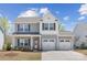 Charming two-story home featuring a two-car garage and beautifully landscaped front yard, with light-grey siding at 314 Contentment Dr # 192B, Locust, NC 28097