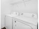 Bright laundry room with a white washer and dryer and wire shelving above at 314 Contentment Dr # 192B, Locust, NC 28097