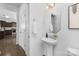 Modern powder room with a pedestal sink, decorative mirror, and neutral color scheme, conveniently located near the kitchen at 314 Contentment Dr # 192B, Locust, NC 28097