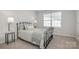 Cozy bedroom featuring a wrought iron bed frame, soft lighting and neutral decor at 336 F Lincoln St, Concord, NC 28025