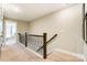 Upstairs hallway with wood-railed staircase and neutral walls leading to bedrooms at 4229 Black Ct # 196, Harrisburg, NC 28075