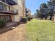 Condo exterior features patio, small yard and mature trees near a pond at 4814 Spring Lake Dr # B, Charlotte, NC 28212