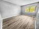 Spacious bedroom with new floors and a window overlooking the lawn at 4814 Spring Lake Dr # B, Charlotte, NC 28212