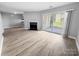 Bright living room with modern floors, a fireplace, and sliding glass doors to the outside at 4814 Spring Lake Dr # B, Charlotte, NC 28212