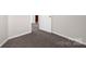 Bedroom features a neutral-toned carpet, white trim, and a white door, creating a bright and inviting space at 4917 Spruce Peak Rd, Charlotte, NC 28278