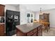 Open dining space with a view of the backyard, adjacent to the black refrigerator and an island at 4917 Spruce Peak Rd, Charlotte, NC 28278