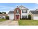 Charming two-story home featuring a red front door, brick accents, green lawn, and attached garage at 4917 Spruce Peak Rd, Charlotte, NC 28278
