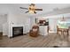 Inviting living room with hardwood floors, a cozy fireplace, a ceiling fan, and an open layout at 4917 Spruce Peak Rd, Charlotte, NC 28278