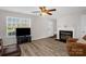 Inviting living room featuring hardwood floors, a fireplace, a ceiling fan, and an open layout at 4917 Spruce Peak Rd, Charlotte, NC 28278