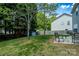 Landscaped backyard featuring mature trees, patio and storage shed, perfect for relaxing and entertaining at 513 Buttercup Way, Fort Mill, SC 29715