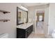 Bathroom featuring double sinks, framed mirror, and an open doorway to bedroom at 513 Buttercup Way, Fort Mill, SC 29715