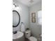 Powder room with vanity, toilet, decorative oval mirror, and natural light at 513 Buttercup Way, Fort Mill, SC 29715