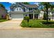 Traditional two-story home featuring a lush front lawn, attached garage, and covered front porch at 513 Buttercup Way, Fort Mill, SC 29715