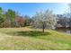 A lush green backyard featuring mature trees and a serene pond creates a peaceful and scenic outdoor space at 529 Langley Rd, Lancaster, SC 29720