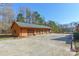 A detached four-car garage with ample parking space situated on a concrete driveway and orange colored siding at 529 Langley Rd, Lancaster, SC 29720