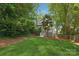 Landscaped backyard with a well-maintained lawn, trees, and charming house at 545 Dilworth Mews Ct, Charlotte, NC 28203