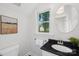 Clean bathroom with a black countertop sink, a round mirror, and a window that offers natural light and a pleasing view at 545 Dilworth Mews Ct, Charlotte, NC 28203