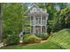 Charming home featuring a multi-level porch, detailed railing, and lush, mature landscaping surrounding the property at 545 Dilworth Mews Ct, Charlotte, NC 28203