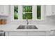 Bright kitchen with a stainless steel sink, white countertops, and three windows that let in natural light and offer a peaceful view at 545 Dilworth Mews Ct, Charlotte, NC 28203