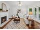 Cozy living room with a fireplace, decorative mirror, a white sofa, hardwood floors, and a patterned rug at 545 Dilworth Mews Ct, Charlotte, NC 28203