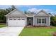 Charming single-story home with stone accents, gray siding, and a well-manicured lawn at 5621 Skinny Dr, Charlotte, NC 28215