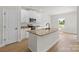 Kitchen island featuring granite countertop and sink, providing extra workspace and seating at 5626 Skinny Dr, Charlotte, NC 28215