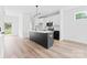 A modern kitchen boasts a black island, white cabinetry, and updated appliances at 600 Legrand St, Shelby, NC 28150
