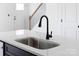 Stylish kitchen with a modern sink, sleek black faucet, and elegant countertop with a view of the staircase at 600 Legrand St, Shelby, NC 28150