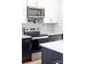 Close-up of kitchen appliances: microwave, stove, white and black cabinets, and backsplash at 600 Legrand St, Shelby, NC 28150