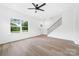 Bright living room features light wood flooring, a ceiling fan, and a staircase at 600 Legrand St, Shelby, NC 28150