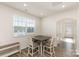 Bright dining area with large window, wooden table, and seating for four at 6048 Chelsea Oaks Rdg, Tega Cay, SC 29708