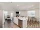 Bright open-concept kitchen island and dining area with wood floors and ample natural light at 6048 Chelsea Oaks Rdg, Tega Cay, SC 29708