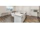 Bright modern kitchen island and dining area with wood floors and ample natural light at 6048 Chelsea Oaks Rdg, Tega Cay, SC 29708