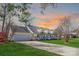 Charming home with a long driveway, manicured lawn, and inviting front porch at sunset at 705 Sagrada Dr, York, SC 29745