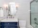 Well-lit bathroom featuring a modern vanity, mirror, toilet, and glass-enclosed shower at 7417 Shadowlake Dr, Charlotte, NC 28226