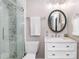 Updated bathroom with a glass door shower, framed oval mirror and modern vanity at 7417 Shadowlake Dr, Charlotte, NC 28226