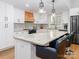 An updated kitchen featuring white cabinets, a central island with barstool seating, and modern appliances at 7417 Shadowlake Dr, Charlotte, NC 28226