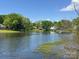 Scenic lake view featuring lush trees and inviting waterfront properties on a sunny day at 7417 Shadowlake Dr, Charlotte, NC 28226