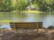 Picturesque lake view with a park bench overlooking the water and a lovely home in the background at 7417 Shadowlake Dr, Charlotte, NC 28226