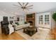 Spacious living room featuring a fireplace, comfortable seating, and french doors to outside at 7417 Shadowlake Dr, Charlotte, NC 28226