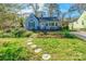 Charming home with stone pathway leading to a cozy front porch surrounded by lush landscaping and a well-maintained lawn at 764 Hawthorne Ln, Rock Hill, SC 29730